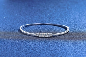 Close-up of S925 silver bracelet with five brilliant round cut stones on blue stardust