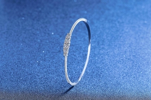 Close-up of S925 sterling silver bangle with three moissanite stones and pave diamonds