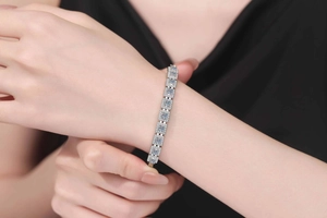 Detailed view of sparkling moissanite silver bracelet on a woman wrist with elegant design