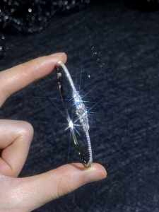 Detailed shot of sparkling moissanite stones micro-paved on a silver cuff bracelet