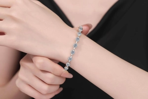 Detail of Moissanite S925 sterling silver pig nose bracelet on model with black clothing