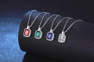 Dettaglio di gemme rettangolari in rosso, verde, blu e trasparente su catene in argento