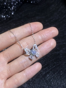 Detail of a butterfly pendant in S925 silver with a 1ct moissanite on a black background