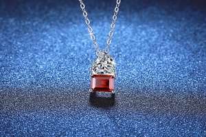 Macro view of S925 silver necklace featuring a heart diamond and emerald-cut ruby pendant