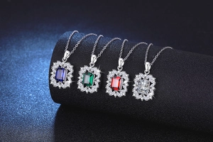 Macro detail of four emerald-cut gemstone pendants in blue, green, red and clear tones