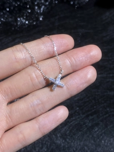 Vue rapprochée du pendentif croix en argent S925 avec moissanite scintillante sur la main