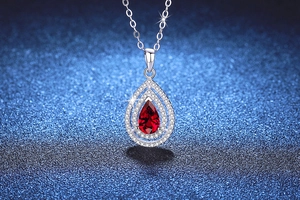 Macro detail of pear-cut ruby pendant with double halo stones on S925 silver chain