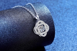 Détail macro du pendentif cœur en argent S925 avec moissanite sur socle bleu