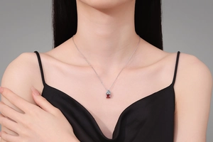 Close-up of S925 silver necklace with rectangular red gemstone pendant on model neck