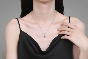 Close-up of a S925 sterling silver moissanite necklace worn on the collarbone of a model