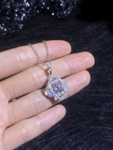 Gros plan du collier avec pendentif fleur en argent 925 et pierre moissanite brillante