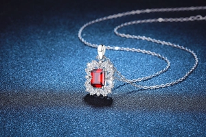 Macro shot of S925 sterling silver necklace with square red gemstone and diamond halo