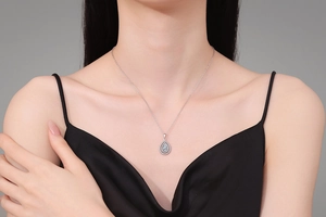 Close-up of S925 sterling silver pear-shaped emerald pendant necklace on model