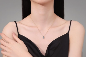 Nahaufnahme einer eleganten Goldkette mit birnenförmigem blauem Saphir-Anhänger
