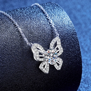 S925 sterling silver butterfly necklace with a 1 carat moissanite on a blue display stand