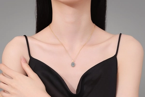Detalle de collar dorado con moissanita y colgante de halo azul puesto en una modelo