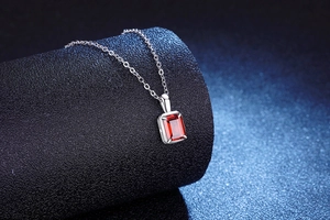Macro-opname van een rode robijnrode hanger aan een S925 zilveren ketting met sterren