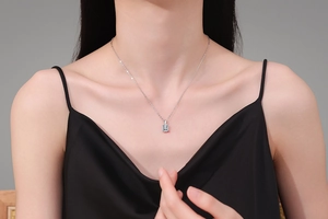 Zilveren ketting met stralende smal geslepen zirkoon hanger gedragen door een model