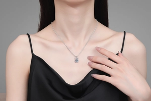 Detail of S925 sterling silver bow necklace with 1ct moissanite pendant on collarbone