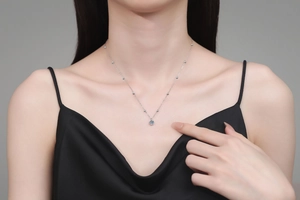 Macro shot of 925 sterling silver pearl chain necklace with 0.5ct moissanite pendant on model