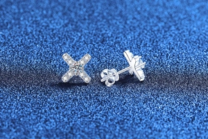 Macro detail of S925 sterling silver X-shaped earrings featuring moissanite pavé stones