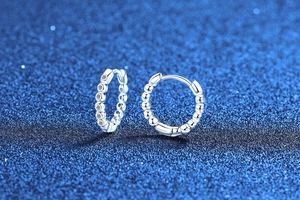 Macro shot of S925 sterling silver hoop earrings featuring polished beads and clear zircon