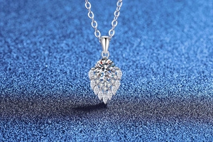 Macro shot of S925 sterling silver water drop pendant with 1ct moissanite on blue background