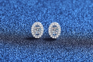 Macro detail of oval S925 sterling silver moissanite studs with halo setting on blue background