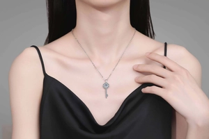 Close-up of S925 sterling silver key necklace with brilliant moissanite pendant on model