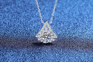 Macro shot of silver geometric triangle pendant with brilliant round cut moissanite stone