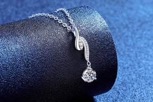 Vista macro di un ciondolo in moissanite con curve eleganti e gemma tonda brillante