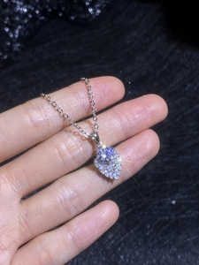 Close-up of S925 sterling silver water drop pendant with 1ct moissanite held in hand