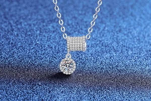 Macro shot of Moissanite necklace with shimmering cylinder buckle and round diamond pendant