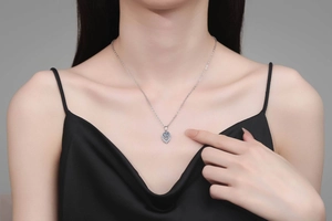 Macro shot of S925 silver necklace with teardrop blue moissanite pendant on model
