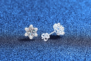 Macro shot of silver S925 moissanite snowflake earrings with mini pearls and zircon stones