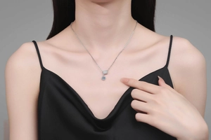Moissanite pendant necklace on model with silver chain and cylinder diamond setting