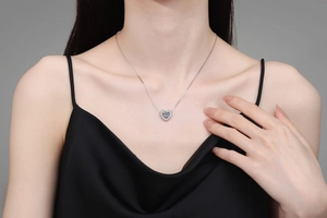 Close-up of heart-shaped 925 silver necklace with 1-carat moissanite on a model