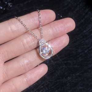Handheld view of a S925 sterling silver dancing moissanite teardrop pendant necklace