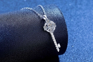 Macro shot of silver sunflower key pendant necklace with moissanite stones and fine chain