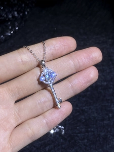 Macro view of sunflower key pendant necklace featuring sparkling moissanite diamonds