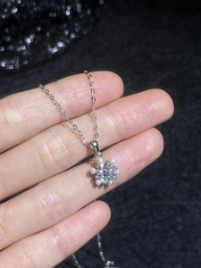 Detailed macro view of S925 silver snowflake pendant with moissanite and pearls