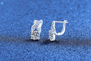 Macro shot of silver infinity twist earrings featuring round brilliant cut moissanite stones