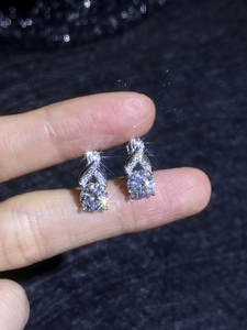 Macro shot of S925 silver moissanite earrings with twisted pavé design and round cut stone