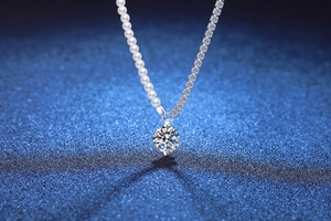 Detail of S925 silver necklace with white pearl chain and round moissanite pendant