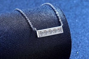 Détail macro du collier barrette en argent avec cinq pierres scintillantes sur support bleu