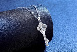 Macro shot of silver crown key pendant with sparkling moissanite stone detail