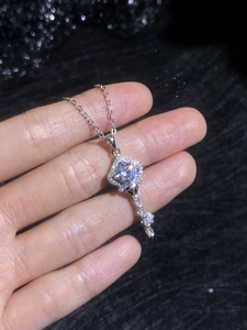 Macro shot of S925 silver crown key necklace pendant with a sparkling moissanite stone