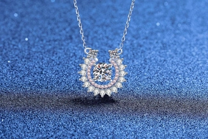 Macro view of horseshoe silver pendant with moissanite and pink diamond halo detail