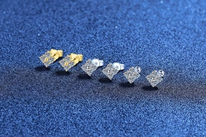 Macro shot of silver and gold square moissanite stud earrings with various secure backings