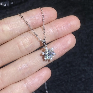 S925 sterling silver snowflake necklace with moissanite and pearl accents on hand